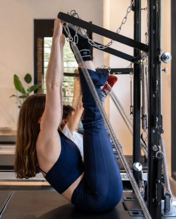 Pratiquante réalisant un exercice de Pilates sur Tower dans le studio Reinforce Pilates à Woluwe-Saint-Lambert